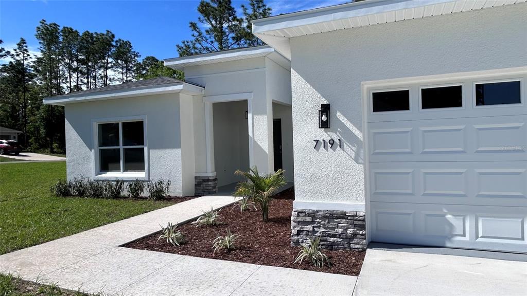 7191 Southwest 133rd Lane Ocala, FL 34473 - Photo 2 of 20 a front view of a house with garden