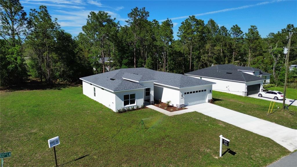 7191 Southwest 133rd Lane Ocala, FL 34473 - Photo 6 of 20 an aerial view of a house with garden space and trees in the background