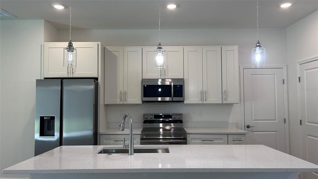 7191 Southwest 133rd Lane Ocala, FL 34473 - Photo 8 of 20 a kitchen with stainless steel appliances granite countertop a refrigerator a stove and a sink