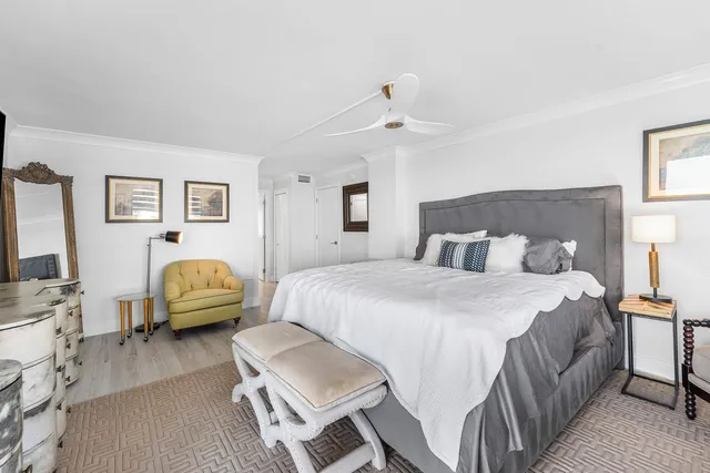 a spacious bedroom with a bed a couch and a flat screen tv