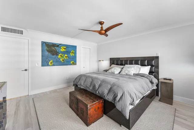 a bedroom with a bed and painting on the wall