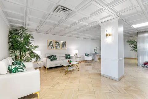 a view of a hallway with potted plants and palm trees
