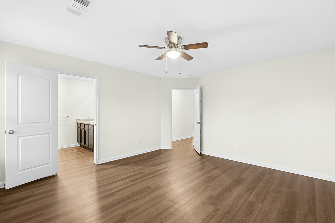 16416 Farmhouse Lane Elgin, TX 78621 - Photo 13 of 25 a view of a livingroom with wooden floor and a ceiling fan