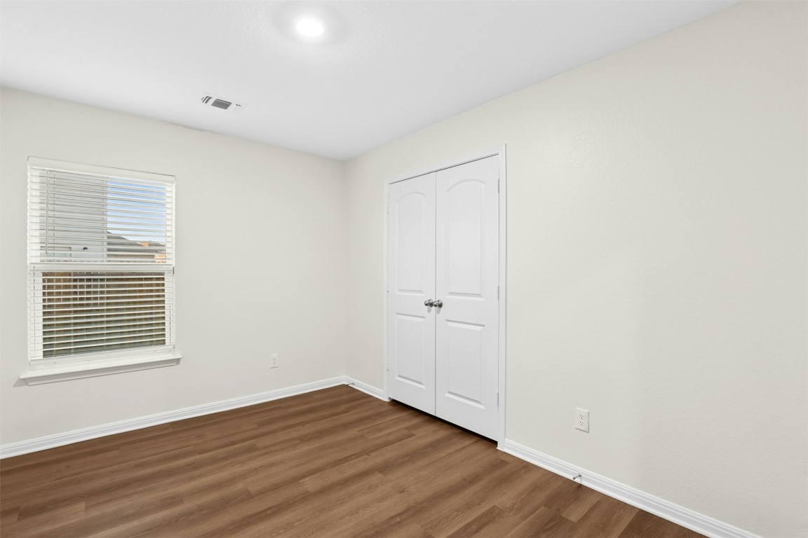 16416 Farmhouse Lane Elgin, TX 78621 - Photo 16 of 25 a view of an empty room with wooden floor and a window