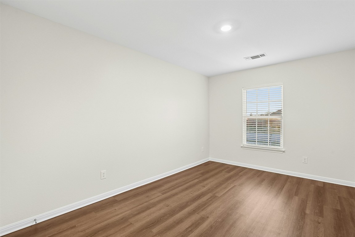 16416 Farmhouse Lane Elgin, TX 78621 - Photo 19 of 25 an empty room with wooden floor and windows