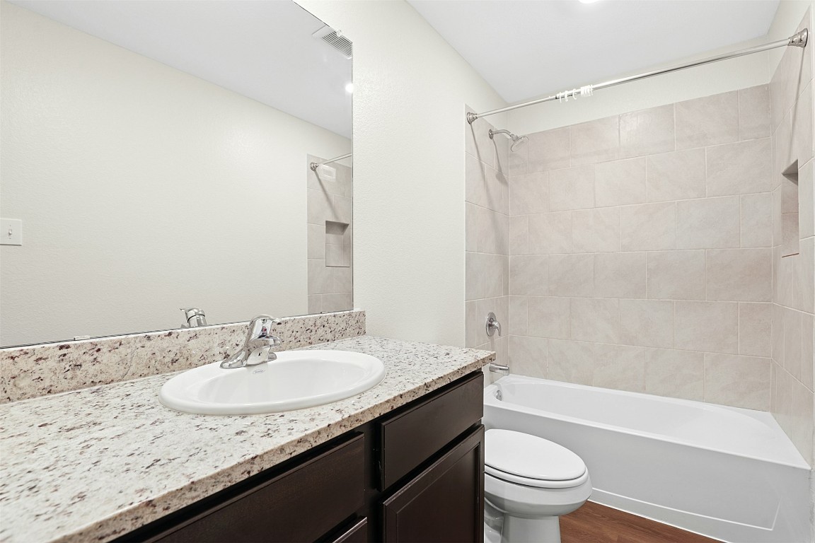 16416 Farmhouse Lane Elgin, TX 78621 - Photo 21 of 25 a bathroom with a granite countertop sink toilet and shower