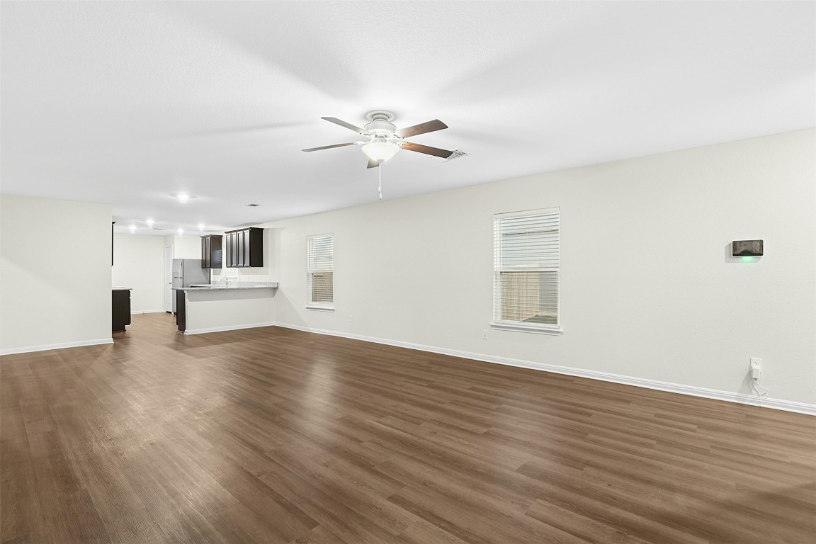 16416 Farmhouse Lane Elgin, TX 78621 - Photo 6 of 25 a view of empty room with wooden floor and ceiling fan