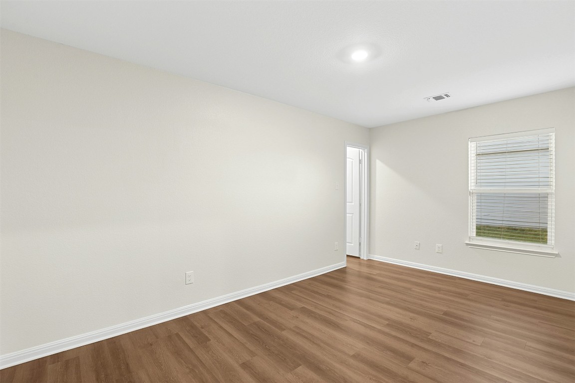 16416 Farmhouse Lane Elgin, TX 78621 - Photo 10 of 25 an empty room with wooden floor and windows