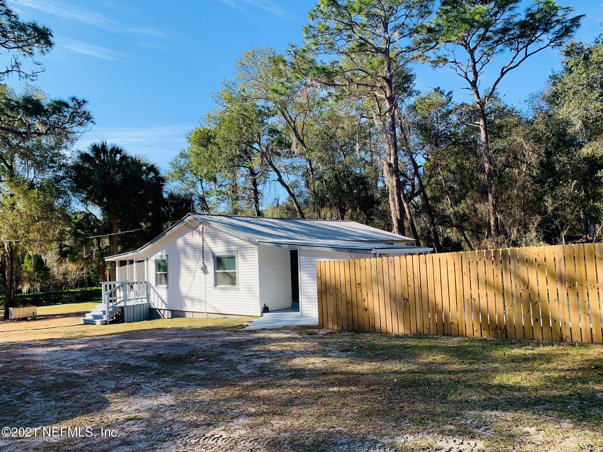 104 Lake Como Point Road Pomona Park, FL 32181 - Photo 4 of 37 a view of a white house with a big yard and large trees