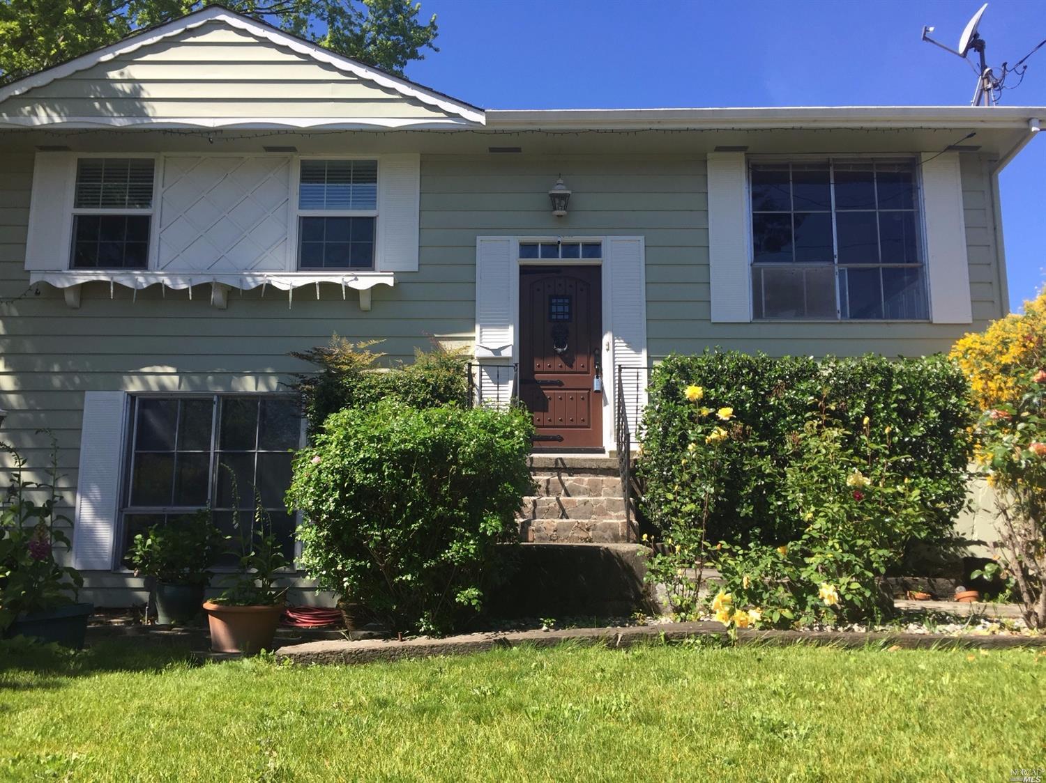 Great curb appeal with beautiful roses and a nice green lawn.