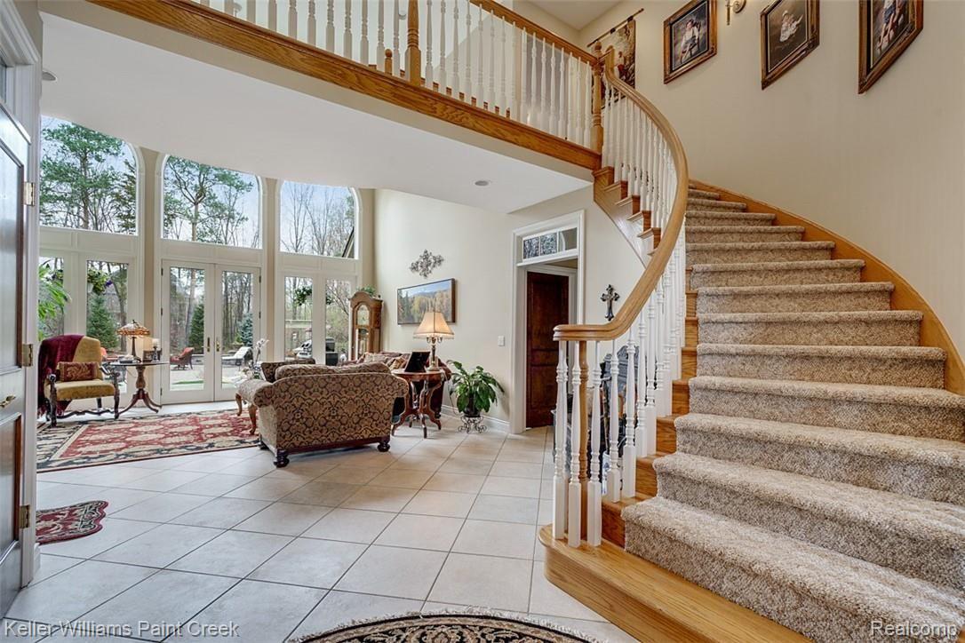 525 Sheldon Court Rochester, MI 48306 - Photo 13 of 66 Enter and you are greeted by a sweeping staircase and open Living Room with floor-to-ceiling windows providing an incredible view.