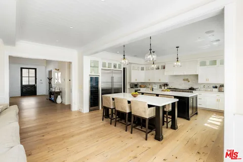 a large kitchen with kitchen island a sink table and chairs