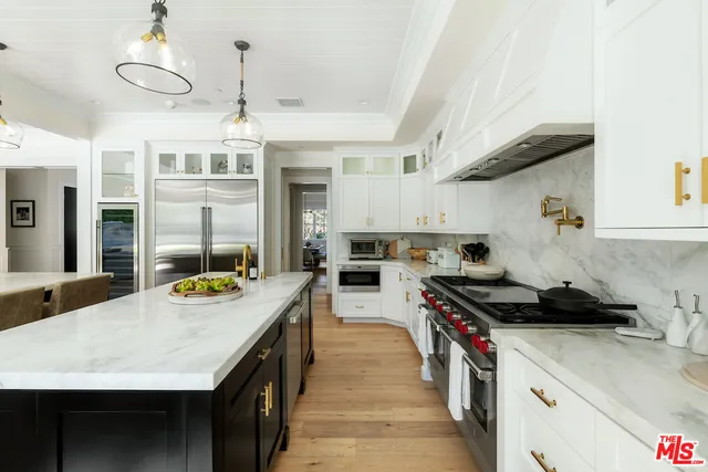 a kitchen with granite countertop white cabinets and sink