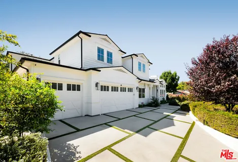 a front view of a house with a yard and potted plants