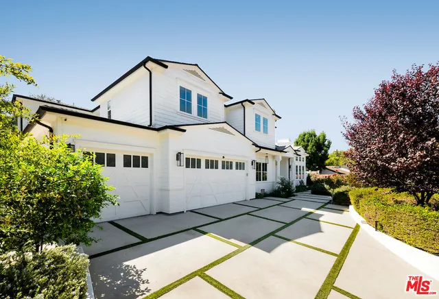 a front view of a house with a yard and potted plants