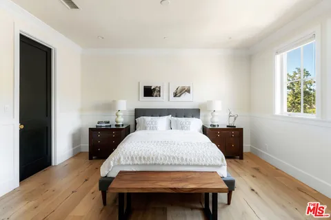 a room with wooden floor and flat screen tv