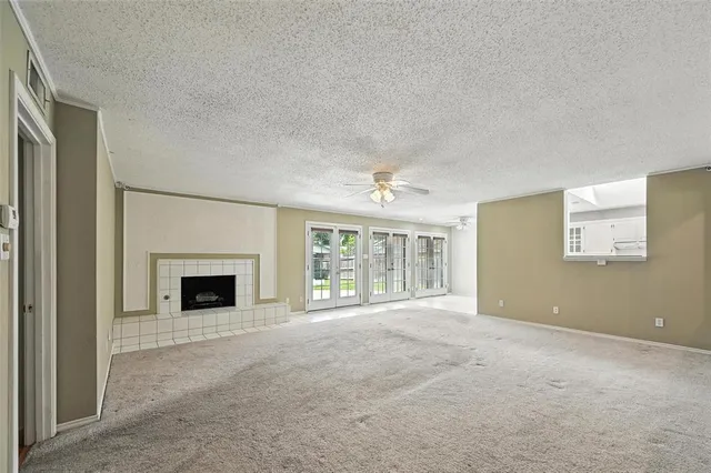 an empty room with windows and fireplace