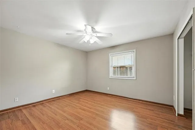 an empty room with wooden floor and window