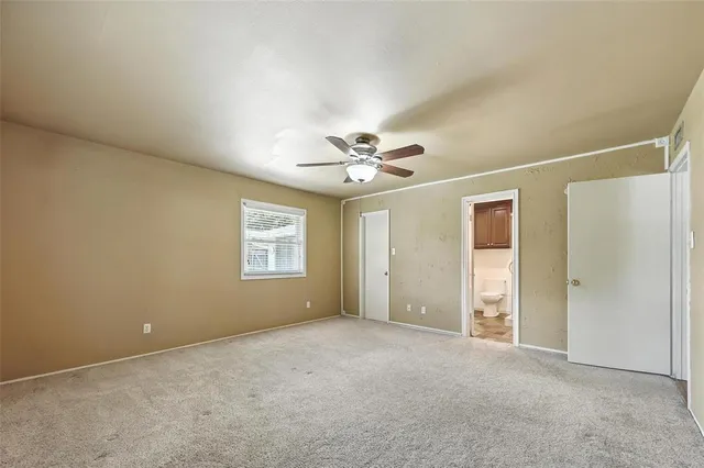 a view of an empty room with a ceiling fan