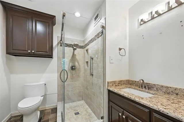 a bathroom with a granite countertop sink toilet and shower