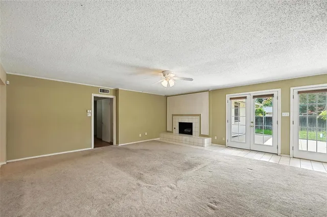 an empty room with floor to ceiling window and fireplace