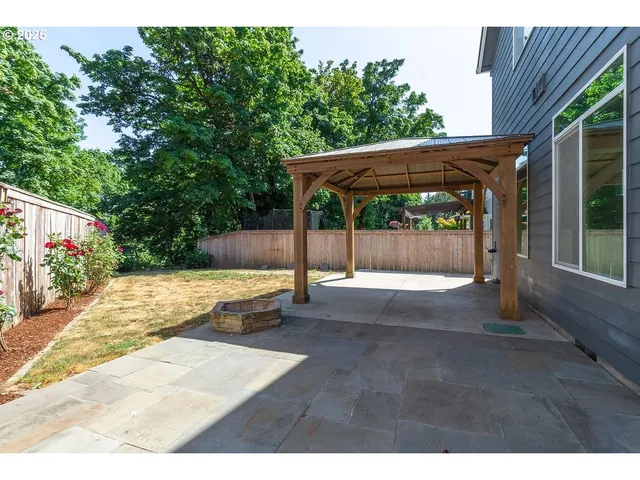 a kitchen with stainless steel appliances granite countertop a stove top oven a sink a dining table and chairs