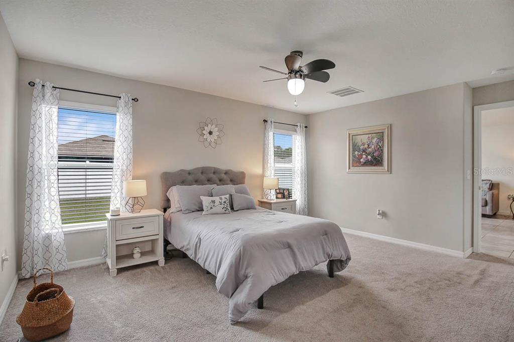 12618 Sandpine Reserve Place Gibsonton, FL 33534 - Photo 16 of 28 a bedroom with a bed and a chandelier