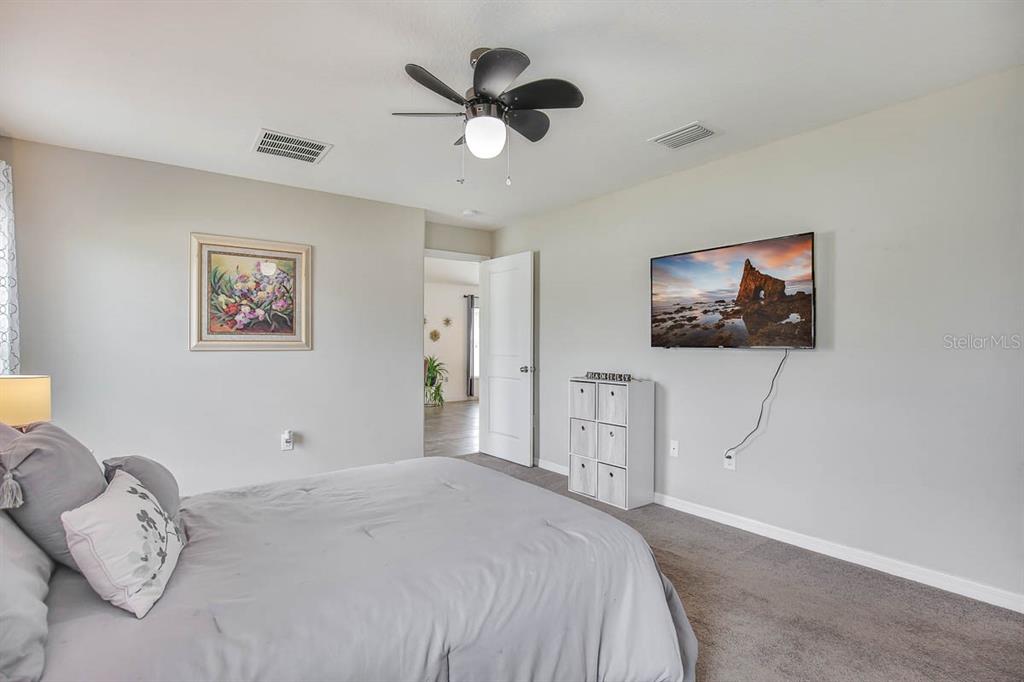 12618 Sandpine Reserve Place Gibsonton, FL 33534 - Photo 17 of 28 a bedroom with a bed and a chandelier