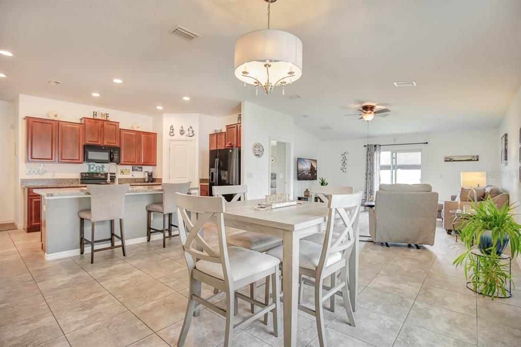 12618 Sandpine Reserve Place Gibsonton, FL 33534 - Photo 5 of 28 a view of kitchen with refrigerator stove dining table and chairs