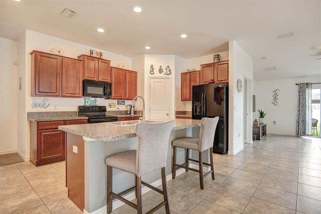 12618 Sandpine Reserve Place Gibsonton, FL 33534 - Photo 6 of 28 a kitchen with stainless steel appliances a refrigerator stove microwave and cabinets