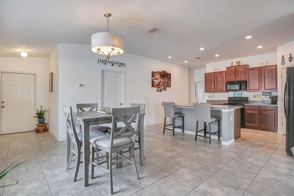 12618 Sandpine Reserve Place Gibsonton, FL 33534 - Photo 10 of 28 a view of a dining room with furniture and a chandelier