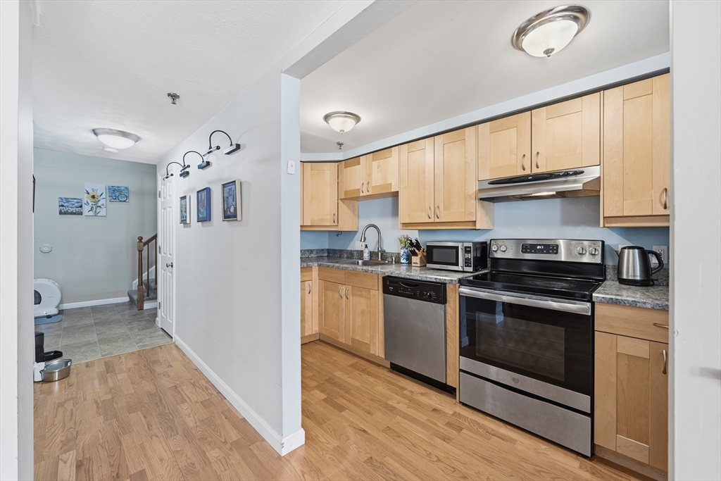 200 Market Street, Unit 217 Lowell, MA 01852 - Photo 2 of 38 a kitchen with granite countertop a stove and a refrigerator