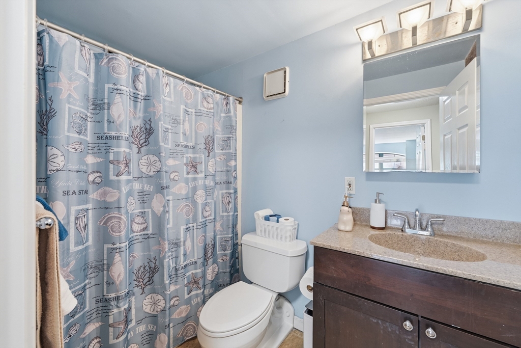 200 Market Street, Unit 217 Lowell, MA 01852 - Photo 26 of 38 a bathroom with a sink a toilet and shower curtain