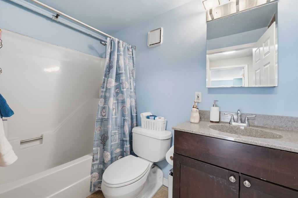 200 Market Street, Unit 217 Lowell, MA 01852 - Photo 27 of 38 a bathroom with a granite countertop sink mirror vanity and toilet