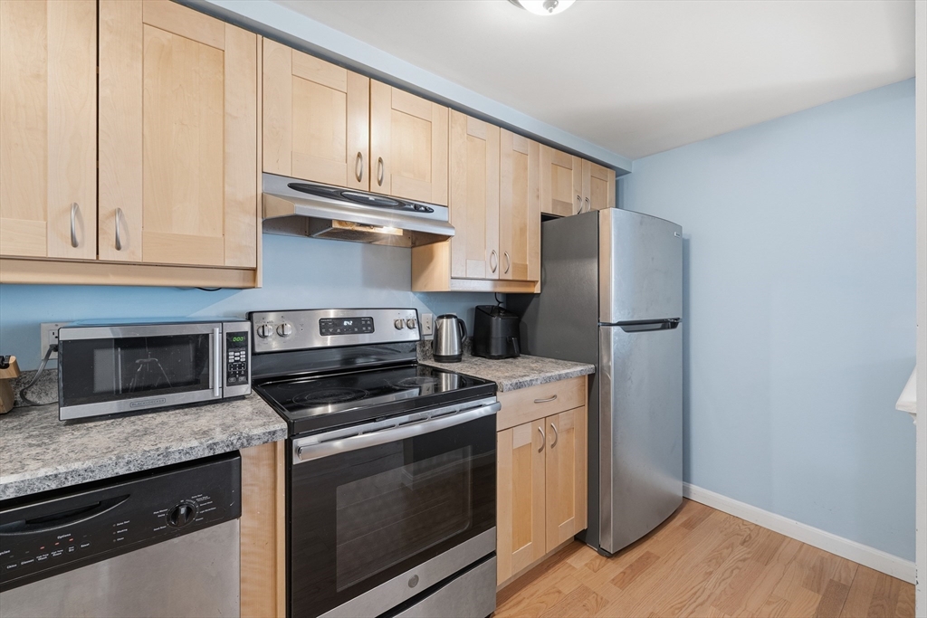 200 Market Street, Unit 217 Lowell, MA 01852 - Photo 3 of 38 a kitchen with granite countertop a refrigerator stove and cabinets