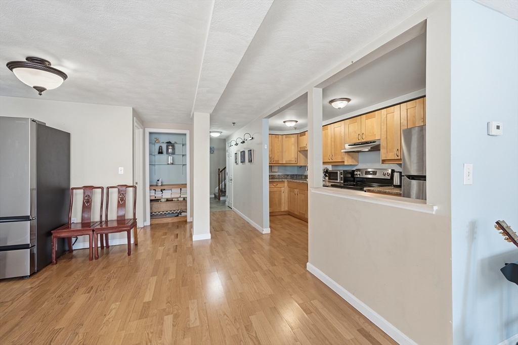 200 Market Street, Unit 217 Lowell, MA 01852 - Photo 5 of 38 a kitchen with stainless steel appliances a refrigerator and wooden floor