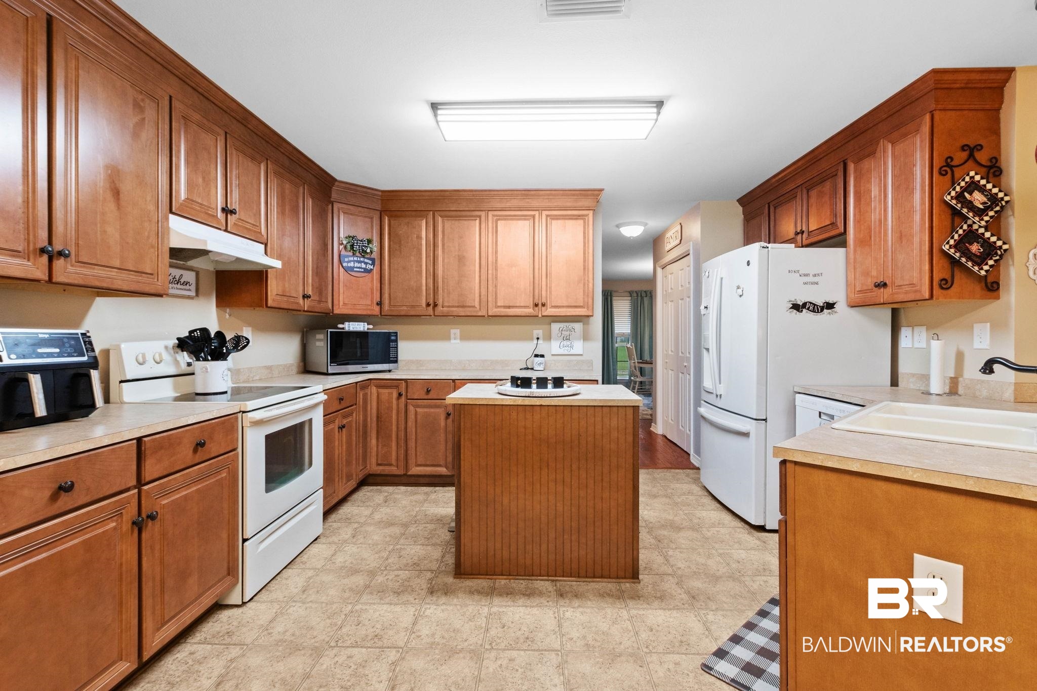 16151 Tolbert Road Bay Minette, AL 36507 - Photo 12 of 74 Kitchen featuring wood cabinetry, light countertops, and tile flooring, Electric Range