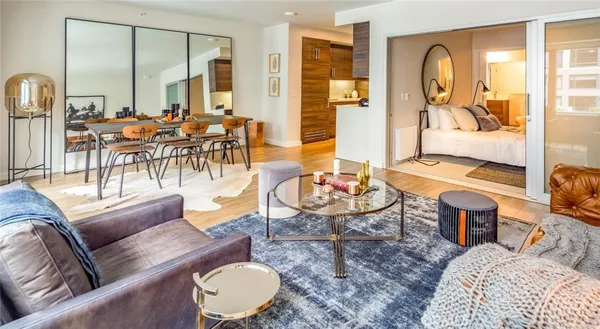 a living room with furniture kitchen view and large windows