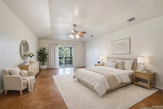 an empty room with chandelier fan and windows