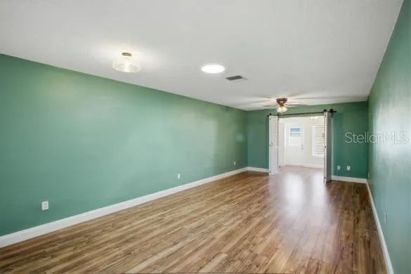 a view of an empty room with wooden floor