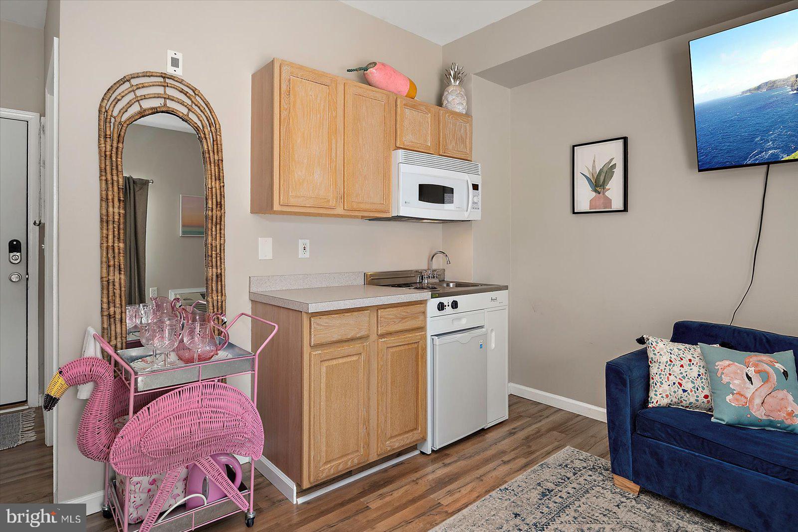 39634 Jefferson Bridge Road, Unit 104 Bethany Beach, DE 19930 - Photo 14 of 28 a kitchen with cabinets a stove and a wooden floors