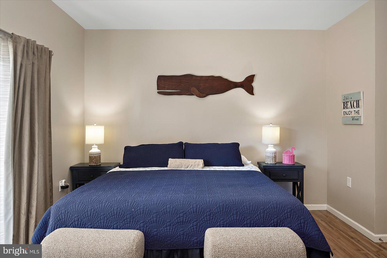 39634 Jefferson Bridge Road, Unit 104 Bethany Beach, DE 19930 - Photo 15 of 28 a bedroom with a bed and wooden floor