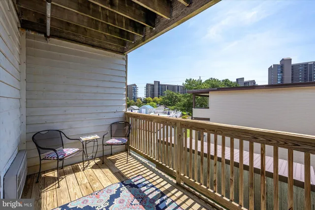 a balcony with wooden floor outdoor seating and city view
