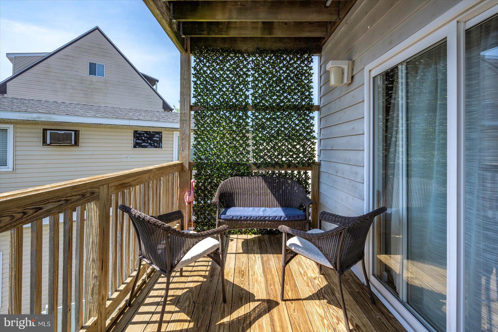 39634 Jefferson Bridge Road, Unit 104 Bethany Beach, DE 19930 - Photo 19 of 28 a view of balcony with wooden floor and outdoor seating