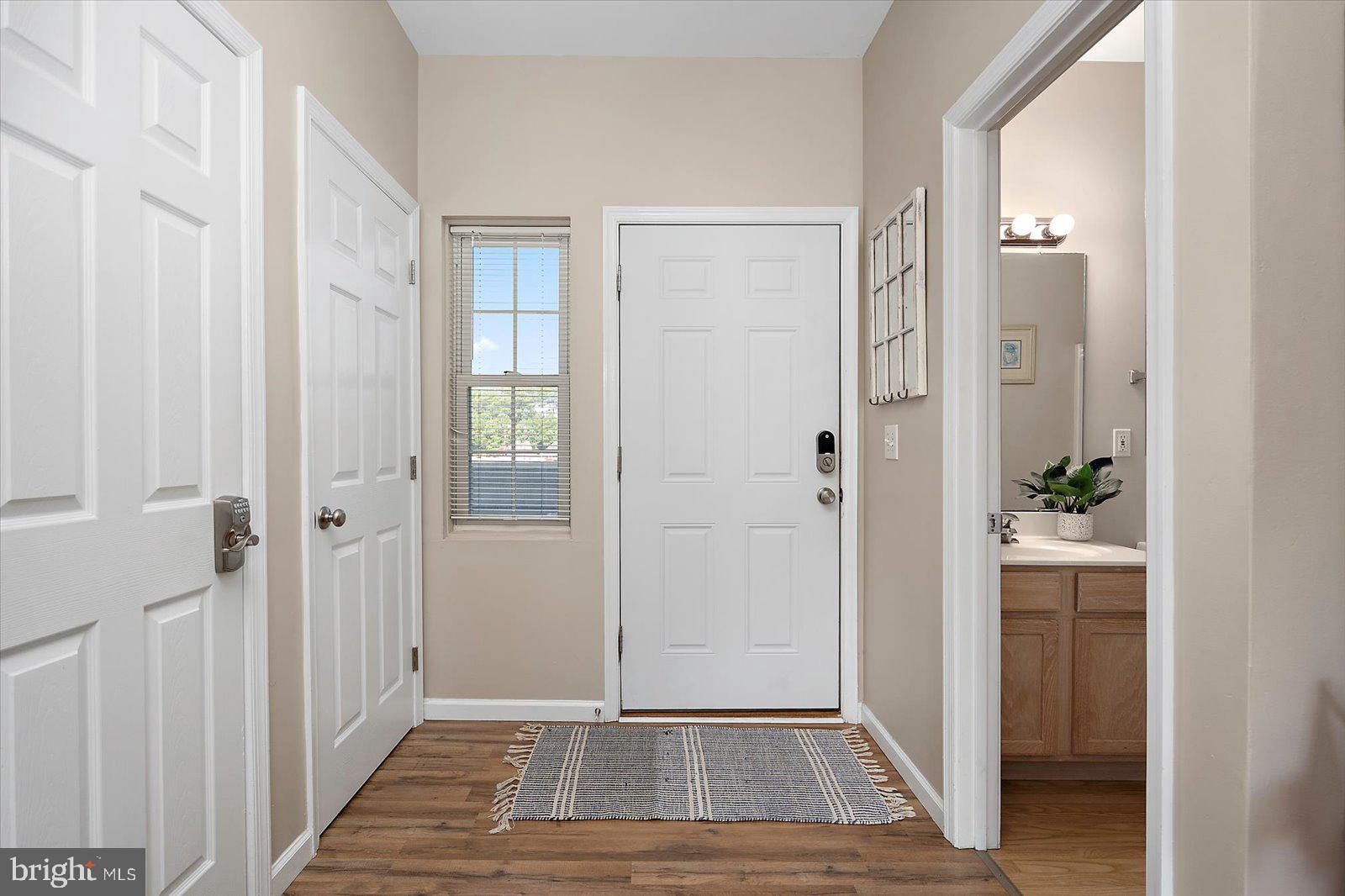 39634 Jefferson Bridge Road, Unit 104 Bethany Beach, DE 19930 - Photo 4 of 28 a view of a hallway with wooden floor and a bathroom