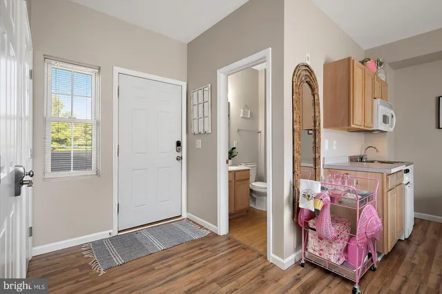 a view of a kitchen with fridge and wooden floor