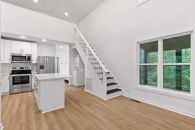 a kitchen with stainless steel appliances a refrigerator sink and microwave
