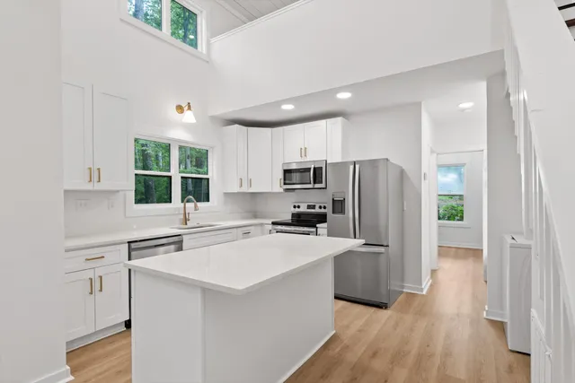 a kitchen with white cabinets and a window