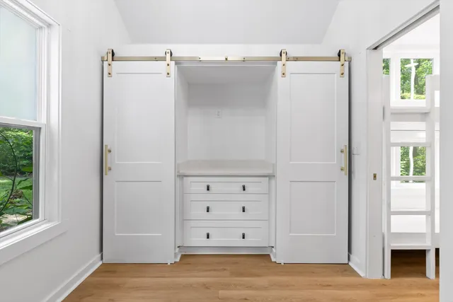 a view of a room with wooden floor closet and windows