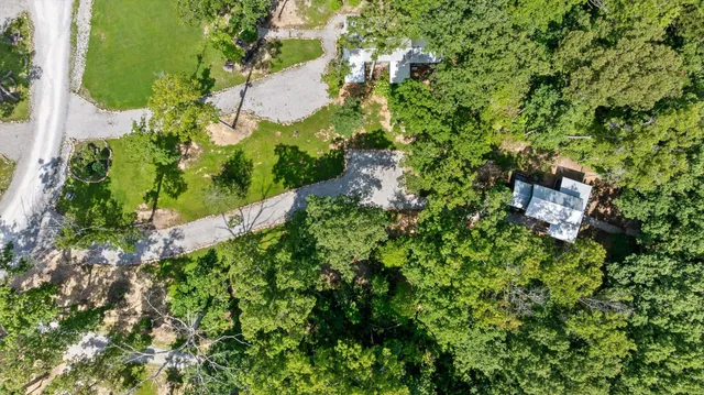 an aerial view of residential houses with outdoor space and trees